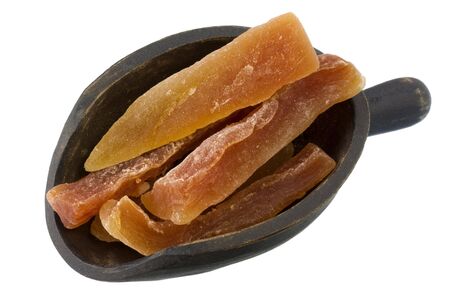 dried papaya spears on a primitive, wooden scoop, isolated on whiteの写真素材