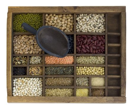 vintage scoop and old, wooden typesetter case with assorted beans, lentils, grains and seeds...