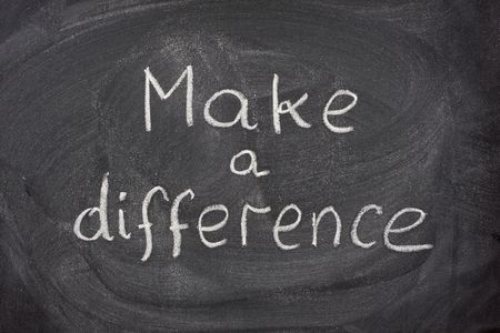 make a difference motivational phrase handwritten with white chalk on blackboard
