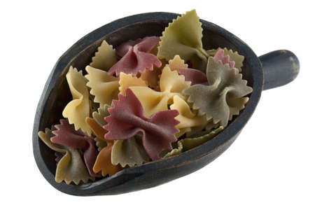 organic vegetable bowties pasta with spinach and red beets on a rustic wooden scoop isolated on...