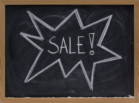 sale announcement sketched with white chalk on a blackboardの写真素材