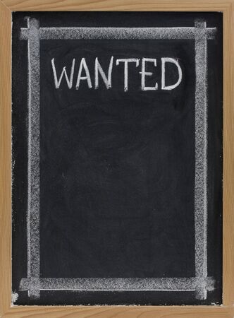 wanted sign handwritten with white chalk on blackboard with copy space belowの写真素材