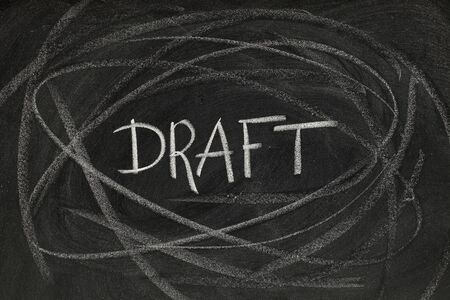 draft headline handwritten with white chalk on blackboard with rough lines and smudges