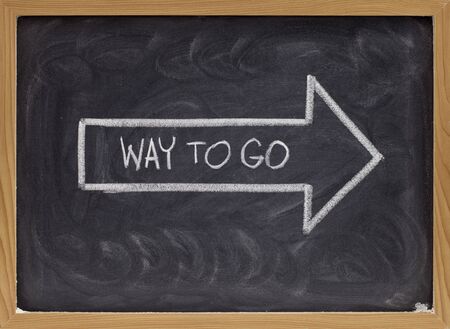 way to go complement handwritten with white chalk inside an arrow on blackboardの写真素材