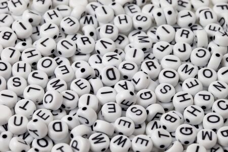 white plastic beads with black letters placed randomlyの写真素材