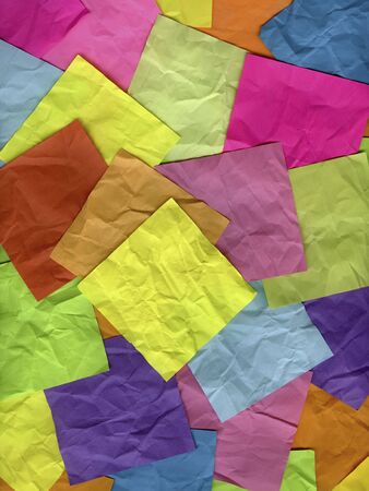 blank yellow sticky note on top of background of crumpled colorful notesの写真素材