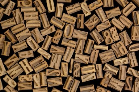 background of randomly placed wooden letterpress printing blocks, black backgroundの写真素材