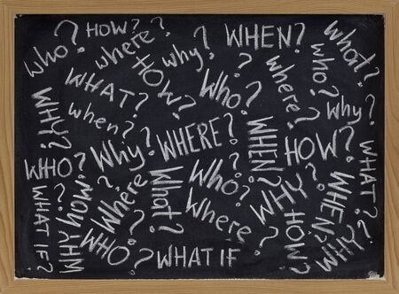 who, what, why, how, where, when, what if questions - white chalk handwriting on blackboardの写真素材