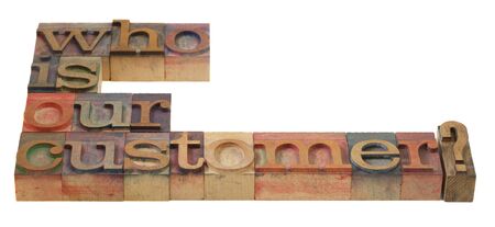 marketing concept - who is our customer question in vintage wooden letterpress printing blocks, stained by color inksの写真素材