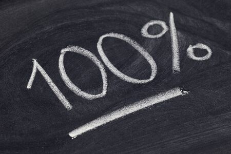 one hundred percent symbol - white chalk handwriting on blackboardの写真素材
