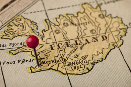 Iceland on vintage 1920s map with a red pushpin on Reykjavik, selective focusの写真素材