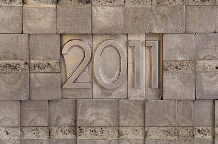 New Year of 2011 - numbers in vintage scratched metal letterpress printing blocks, wall backgroundの写真素材