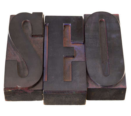 SEO (search engine optimization ) acronym - word in antique letterpress printing blocks, stained by color inks, isolated on whiteの写真素材