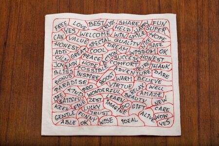 cloud of positive words - handwriting on white napkin, wooden table backgroundの写真素材