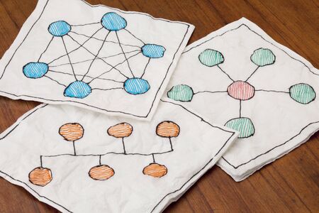 different network schematics sketched on three white napkins placed on a coffee tableの写真素材