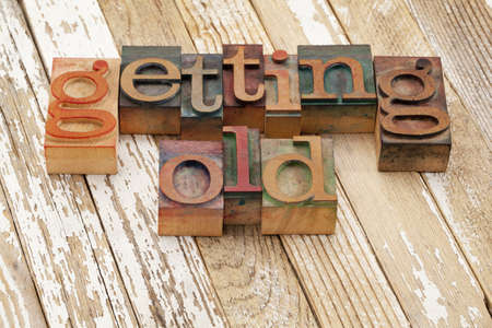 getting old words in vintage wooden letterpress printing blocks against grunge white painted wood surfaceの写真素材