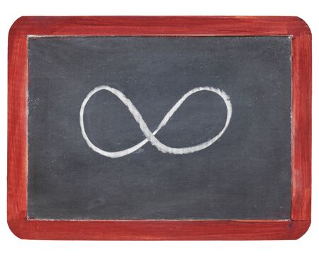 infinity symbol - white chalk  on small slate blackboard, isolated on whiteの写真素材