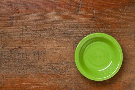 green ceramic bowl on grunge scratched wood surfaceの写真素材