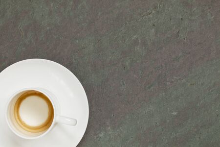 empty white china cup of espresso coffee on slate stone tableの写真素材