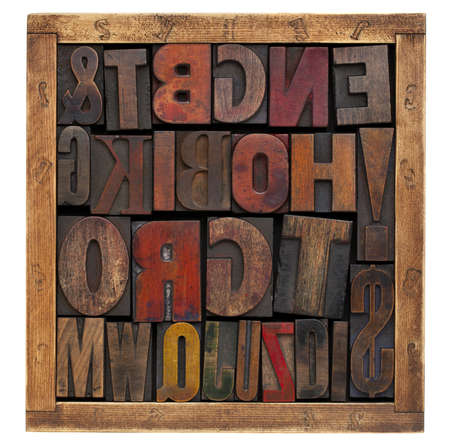 a variety of vintage letterpress printing blocks in a small wooden  box isolated on whiteの写真素材