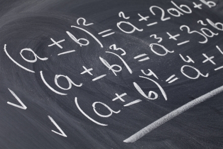 mathematical education concept - algebra equations handwritten with white chalk on blackboardの写真素材