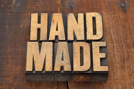 handmade word in vintage letterpress type on grunge wooden background with nails