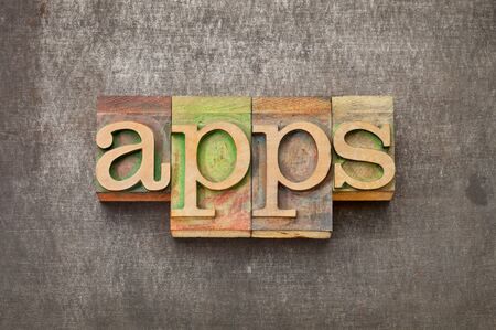 apps (applications) - software  concept - text in vintage letterpress wood type against grunge metal surfaceの写真素材