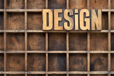 design word in vintage letterpress wood type against divider pattern of a grunge typesetter case