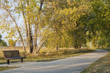 bench and recreational biking trail in Boyd Lake State Park near Loveland, Colorado, fall scenery