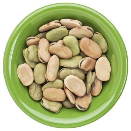 dried fava (broad) bean in a small ceramic bowl isolated on white