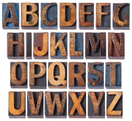 complete English alphabet - collage of 26 isolated vintage wood letterpress printing blocks, scratched and stained by blue, red and black inkの写真素材