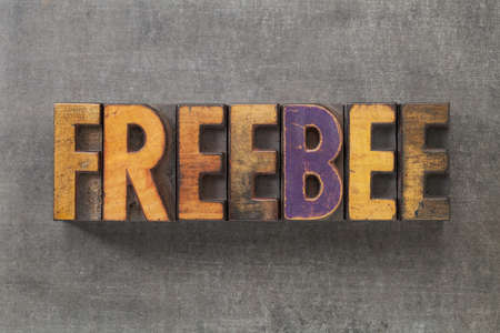 freebee word in vintage letterpress wood type blocks on grunge metal backgroundの写真素材