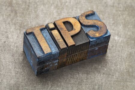 tips word - text in vintage letterpress wood type blocks against a grunge metal backgroundの写真素材