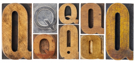 letter Q - 8 isolated vintage letterpress wood and metal type blocks with ink patina, variety of fontsの写真素材