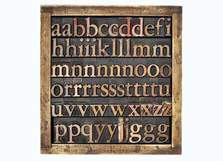 wooden box of vintage letterpress alphabet printing blocks stained by color inks