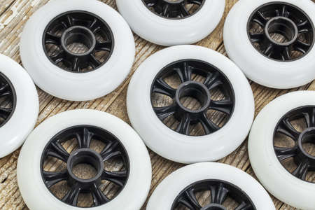 white racing wheels for inline skating on wooden surface