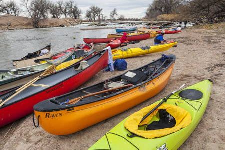 SOUTH PLATTE RIVER, EVANS, COLORADO - APRIL 6: Kayaks and canoes on a river shore below diversion dam during Annual All Club Paddle on April 6, 2013, a popular season opening paddling trip in northern Colorado.のeditorial素材