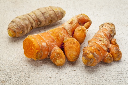 turmeric root on a white painted rough barn wood surface