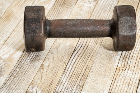 vintage iron rusty dumbbells on weathered white painted barn wood background - fitness conceptの写真素材