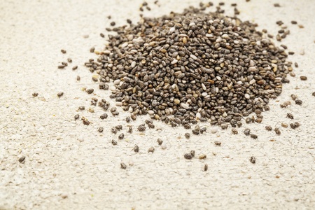a pile of black chia seeds on a rough white painted barn wood backgroundの写真素材