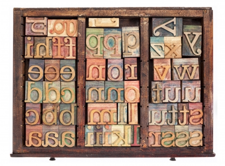 alphabet - letterpress wood type printing blocks in old typesetter drawer isolated on whiteの写真素材
