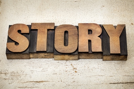 story - a word in vintage letterpress wood type on a grunge painted banr wood backgroundの写真素材