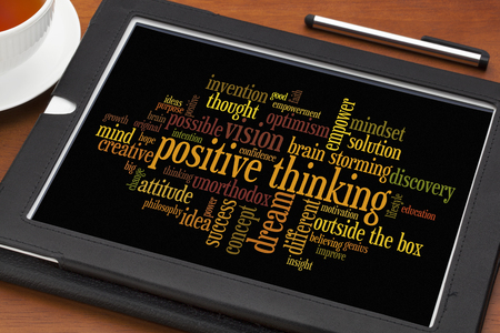 positve thinking concept - word cloud on a digital tablet with a cup of teaの写真素材