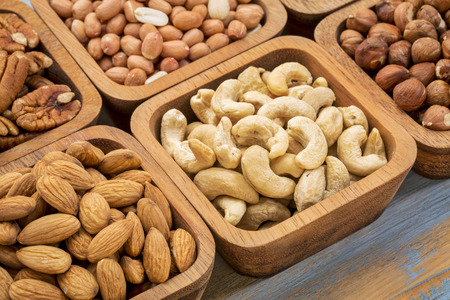 nuts abstract - cashew, pecan, hazelnut, Spanish peanut in wooden bowls