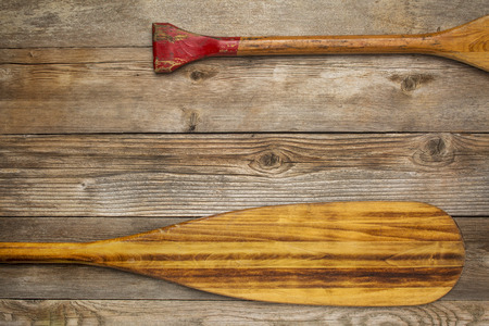 blade and grip of wooden canoe paddle against rustic wood background with a copy spaceの写真素材