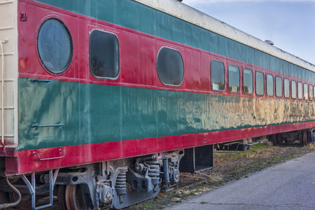 red and green vintage railroad passenger car on a sidetrackの写真素材