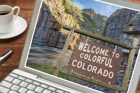 Colorado welcome sign on a laptop with a cup of coffeeの写真素材