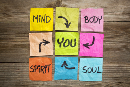 mind, body, spirit, soul and you - balance or wellbeing concept - handwriting on colorful sticky notes against grained woodの写真素材