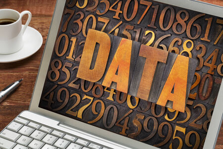 data word in vintage letterpress wood type against number background on a laptop screen -...