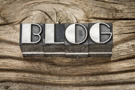 blog word in letterpress metal type printing blocks against weathered grained woodの写真素材